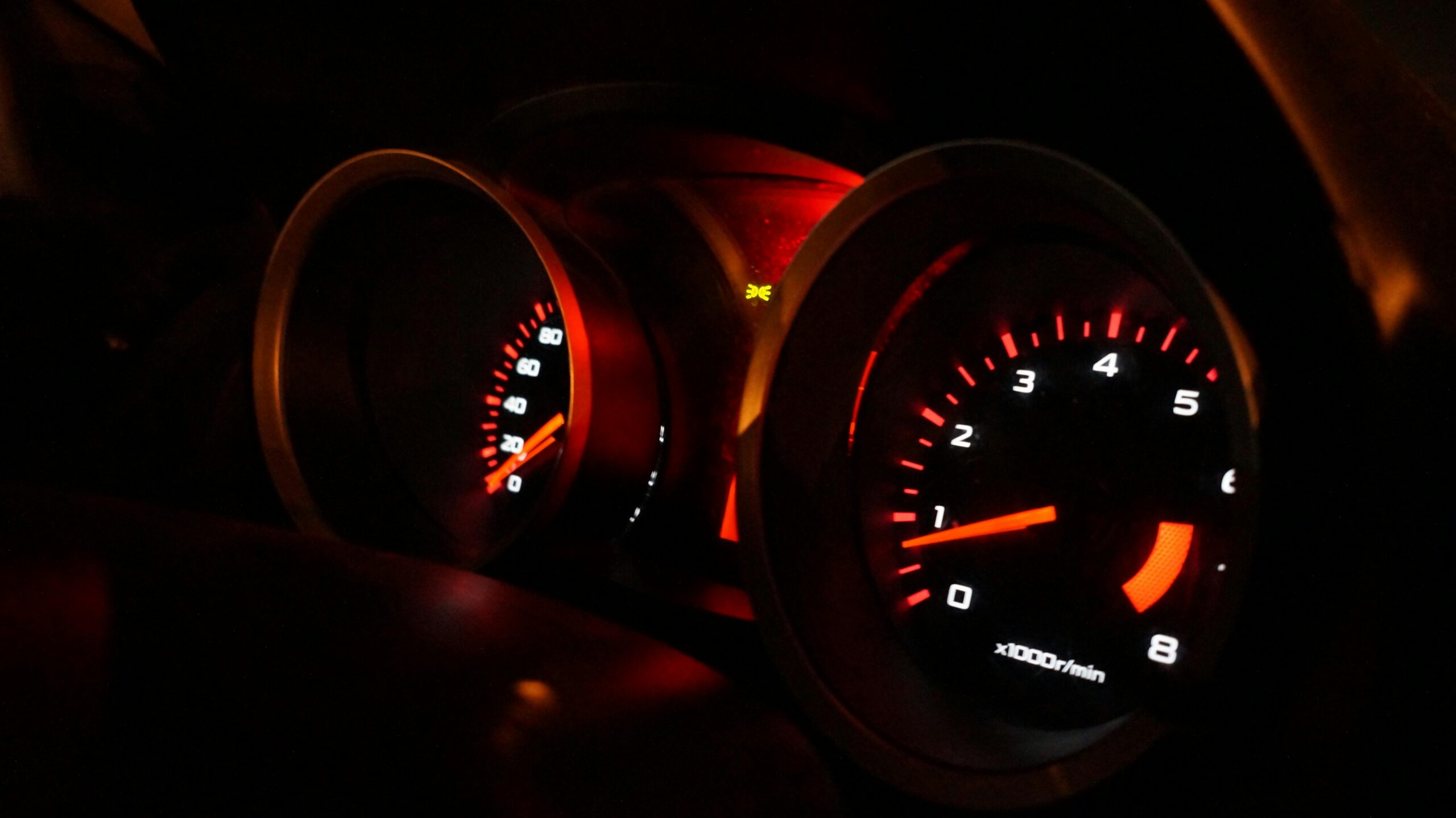 A worried driver looking at a glowing check engine light on the dashboard.